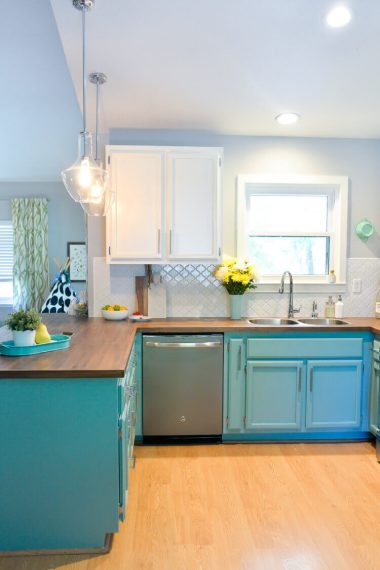 A kitchen with white and teal cabinets