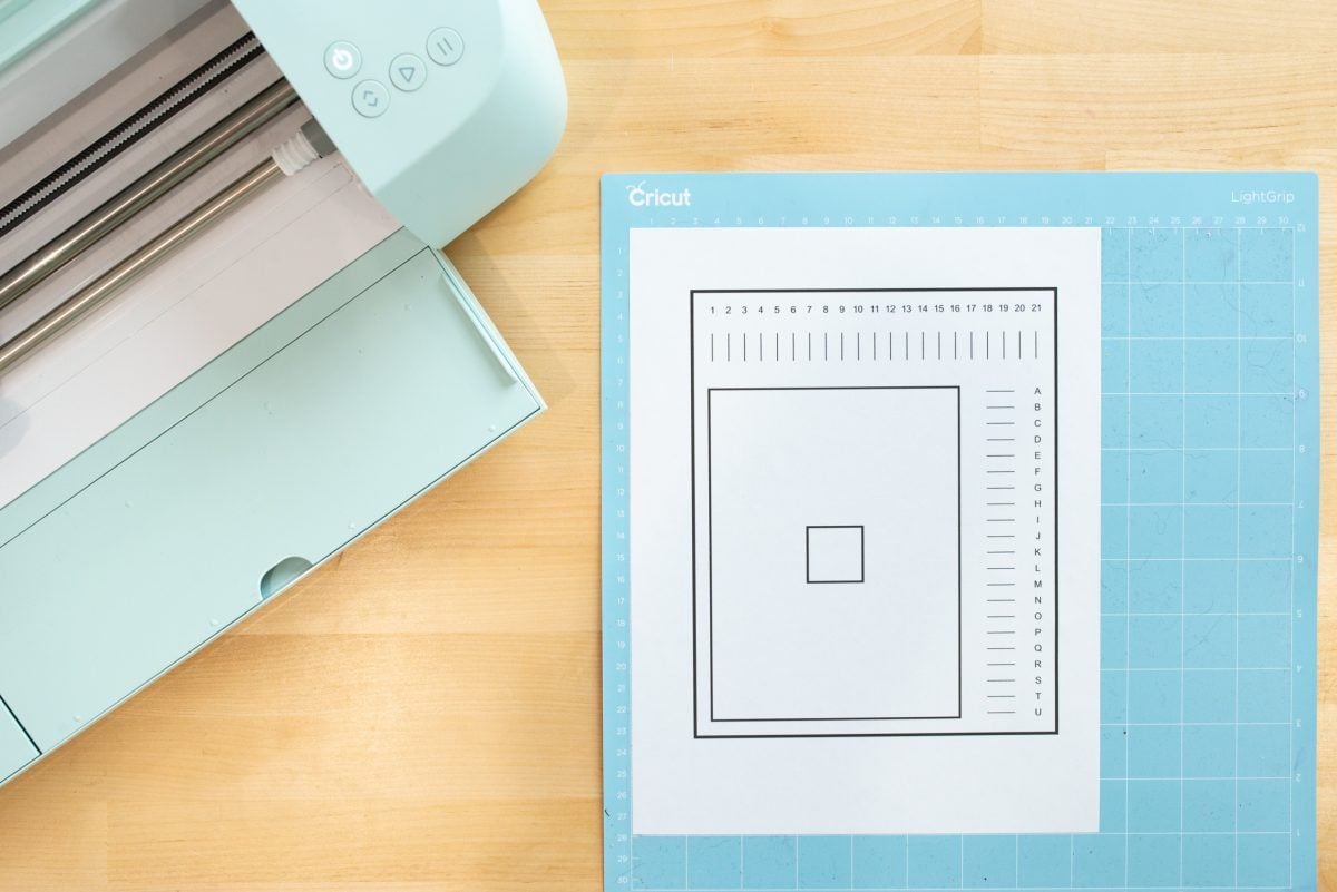 Overhead shot of calibration sheet on Cricut mat with Cricut Explore 3 next to it.