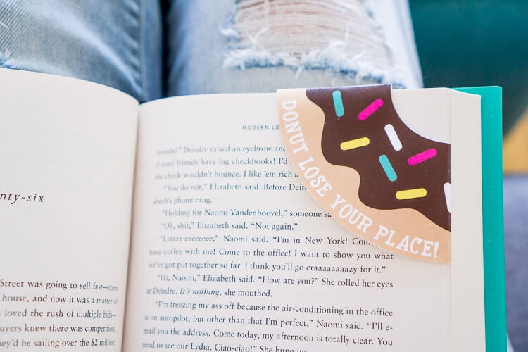 An open book with a donut bookmark in the corner of a page