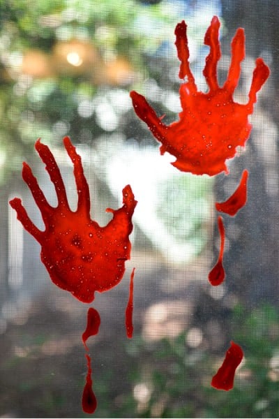 Bloody handprints on a window