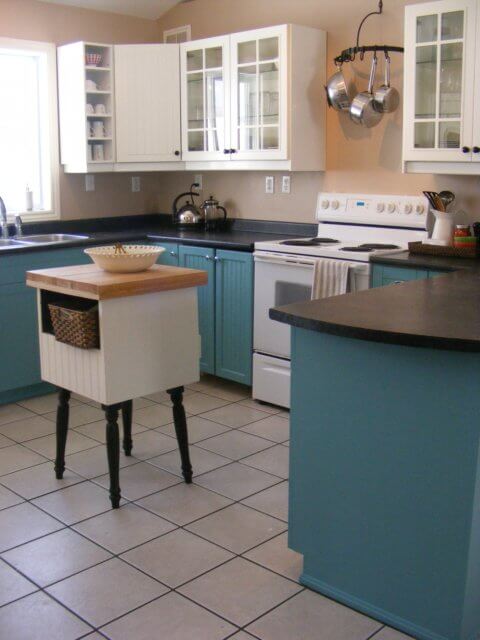 A kitchen with teal bottom cabinets and white uppers