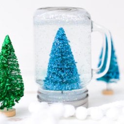 A miniature bottlebrush tree inside of an upside-down Mason Jar sitting on a table