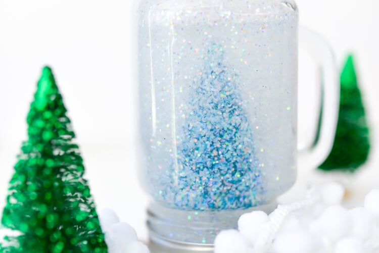 Close up of a miniature bottlebrush tree inside of an upside-down Mason Jar sitting on a table