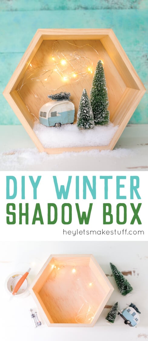 A wooden hexagon shaped shadow box that contains a retro camper with a small bottle brush tree on top of it and two other bottle brush trees standing next to the camper surrounded by fake snow and twinkle lights with advertising from HEYLETSMAKESTUFF.COM for DIY Winter Shadow Box