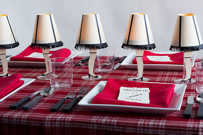 Place settings with decorations down the middle of a table of the \'leg lamp\' from the movie A Christmas Story