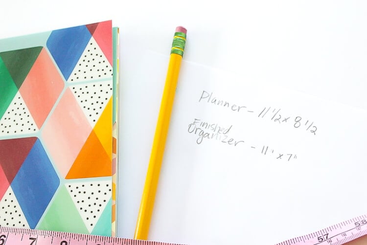 A pencil, a planner, a measuring tape and pencil with a note that says, \"Planner - 11 1/2 x 8\" and \"Finished Organizer - 11\" x 7\" \"