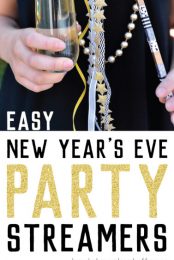 A person wearing a dark navy-blue dress and a string of pearls and holding a flute of champagne and a party streamer with bells with advertising for easy New Year's Eve party streamers by HEYLETSMAKESTUFF.COM