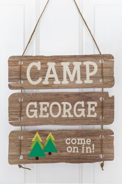 A close up of a sign on a door, and the sign says, "Camp George Come on In!"