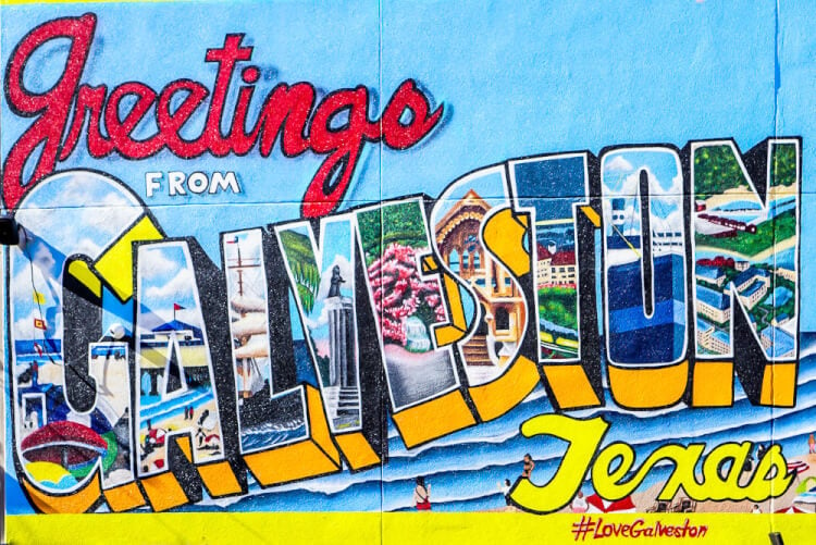 A graffiti covered wall that says, \"Greetings from Galveston, Texas\"