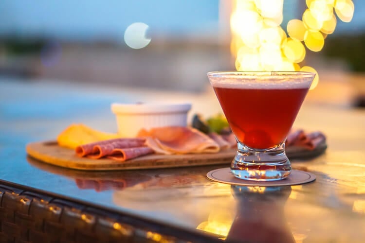 A glass of beer and a platter of food on a table