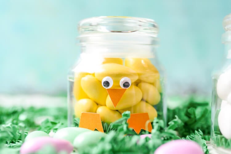 A close up of a jar decorated to resemble a baby chick