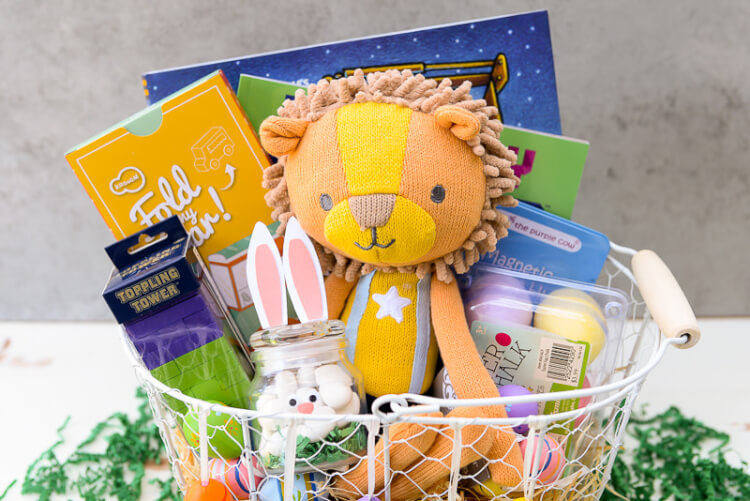 A white wire basket filled with Easter candy and toys