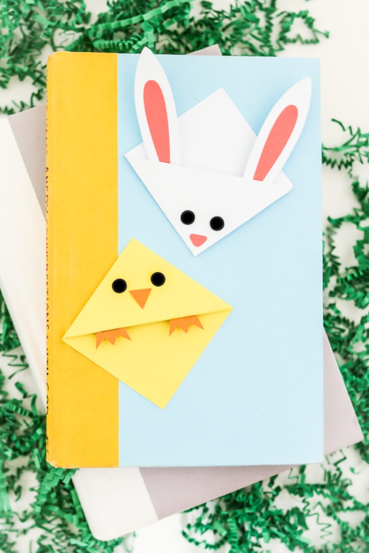 Two books lying on a table with two bookmarks on top of them of a chick and a bunny