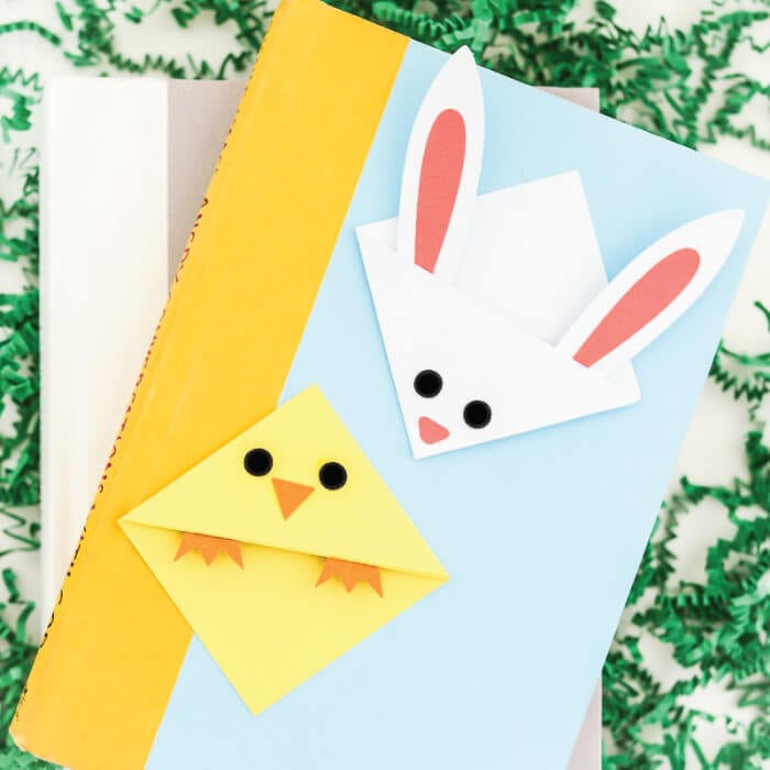 A book with two Easter bookmarks on top of it of a bunny and a chick