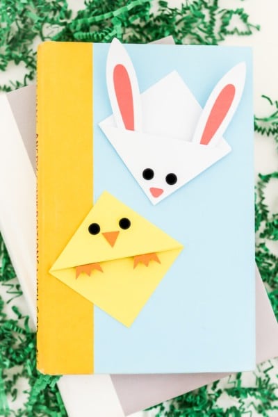 Two books lying on a table with two bookmarks on top of them of a chick and a bunny