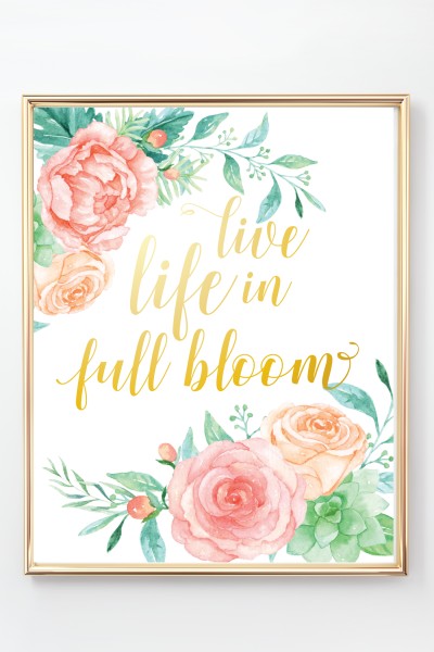 A gold framed floral picture that has a quote saying, "Live Life in Full Bloom"