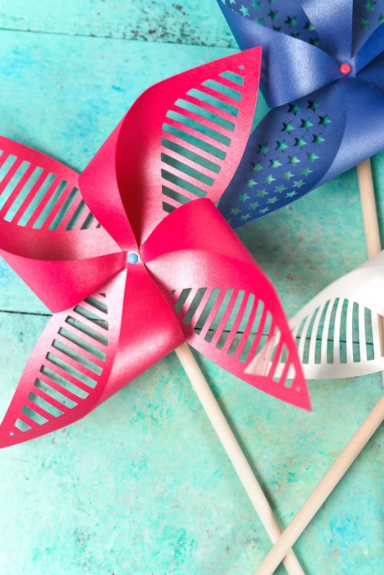 Close up of red, white and blue pinwheels lying on an aqua blue table