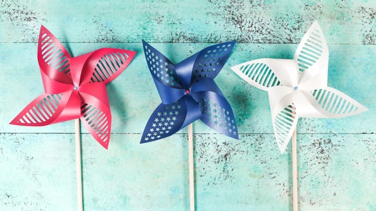 Red, white and blue pinwheels lying on an aqua blue table