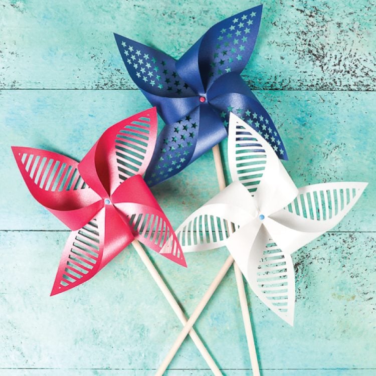 Red, white and blue pinwheels lying on an aqua blue table