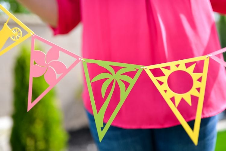 Close up of a lady holding a string of tropical themed party pennants