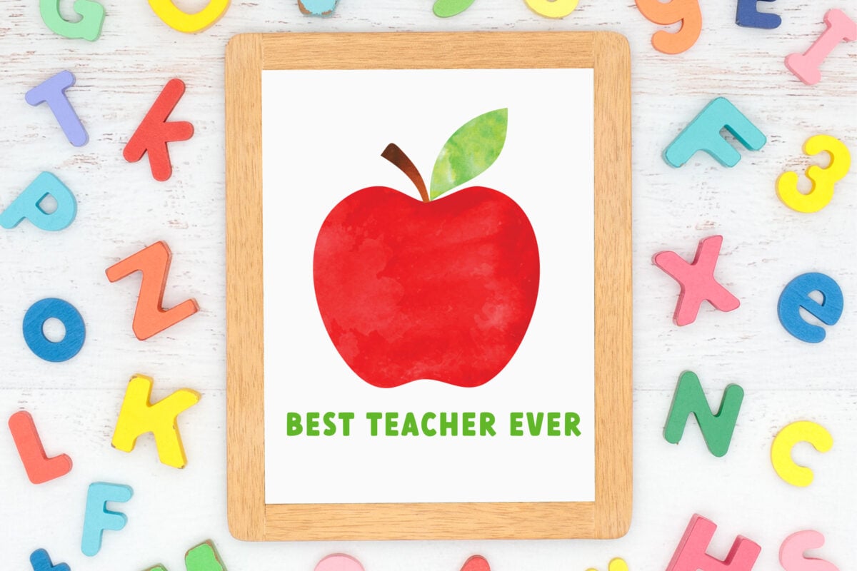 Apple clip art on paper surrounded by letters