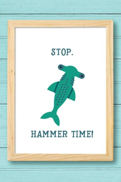 A wooden framed picture of a hammerhead shark and the saying, "Stop" "Hammer Time!"