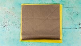 Yellow, green and brown tissue paper on an aqua blue table