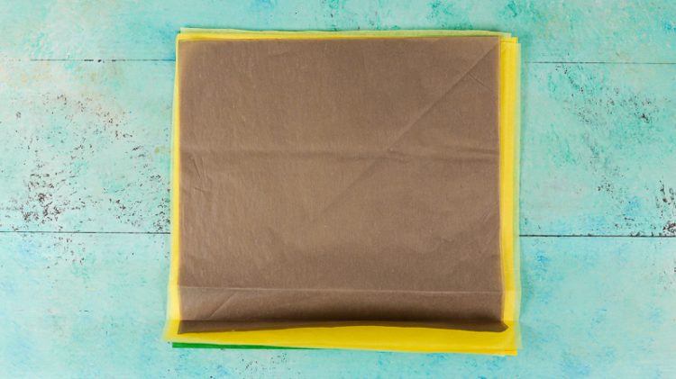 Yellow, green and brown tissue paper on an aqua blue table