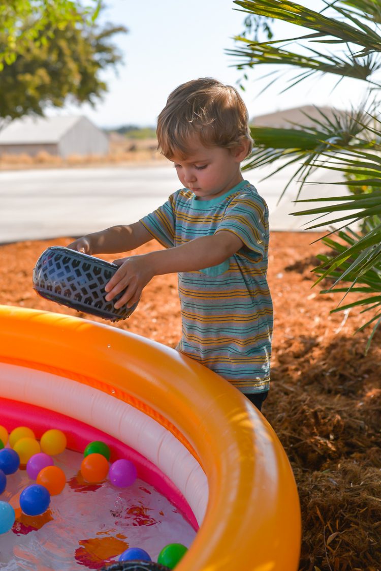 A little boy playing by an inflatable plastic swimming pool