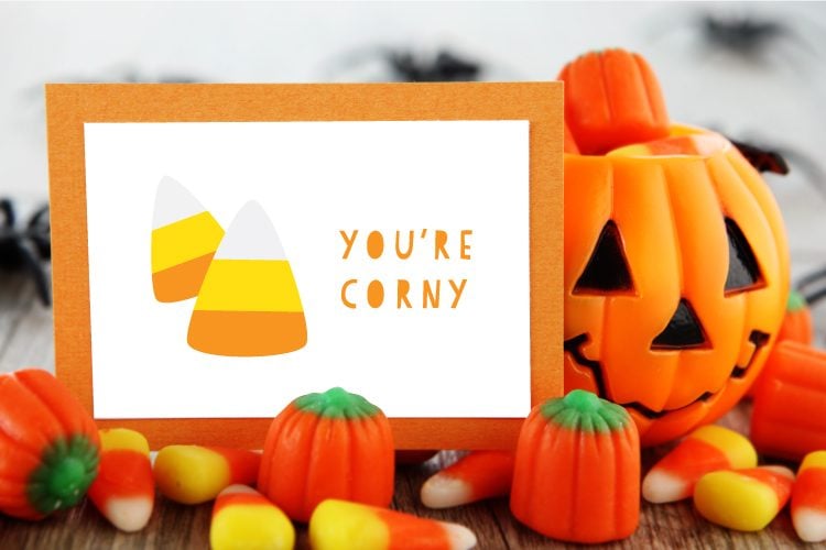 Halloween candy on a table and a card that is decorated with candy corn candy and says, \"You\'re Corny\"