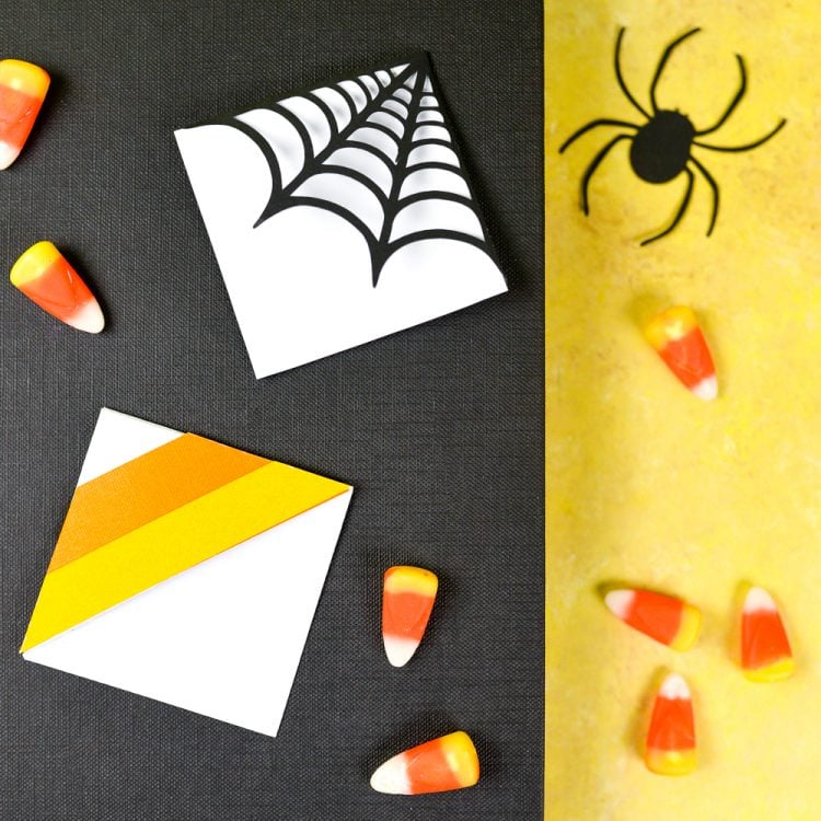 Paper black spider, candy corn candy lying next to two bookmarks decorated for Halloween