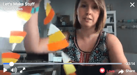 A woman holding up a felt candy corn garland