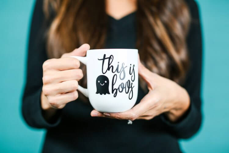 A close up of a person holding a cup, with decal of a ghost and the saying, \"This is Boos\"