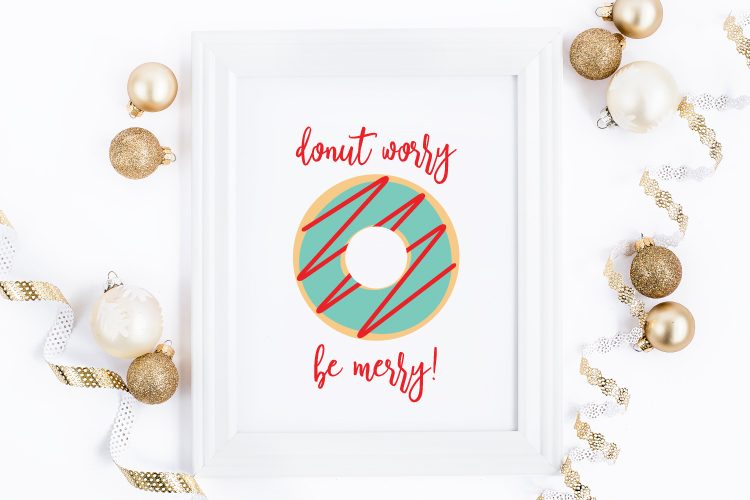 Gold and White Christmas ornaments surrounding a white framed sign that has an image of a donut and the sign says, \"Donut Worry, Be Merry!\"