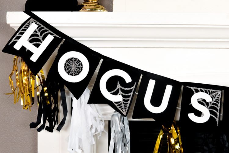 Close up of partial black, white and gold banner that is hanging from a white fireplace mantel