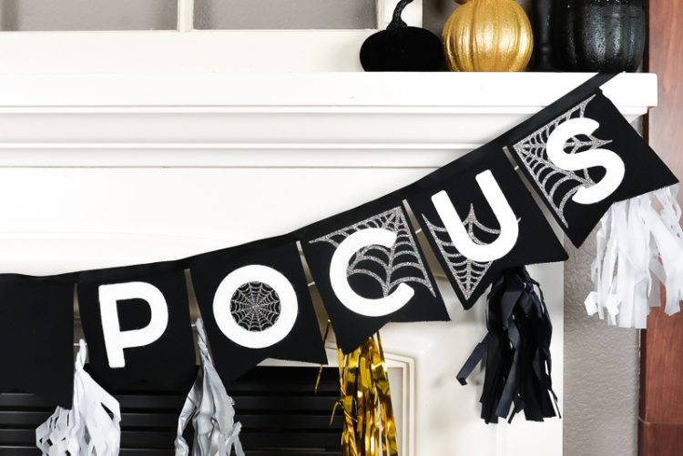 Close up of partial black, white and gold banner that is hanging from a white fireplace mantel