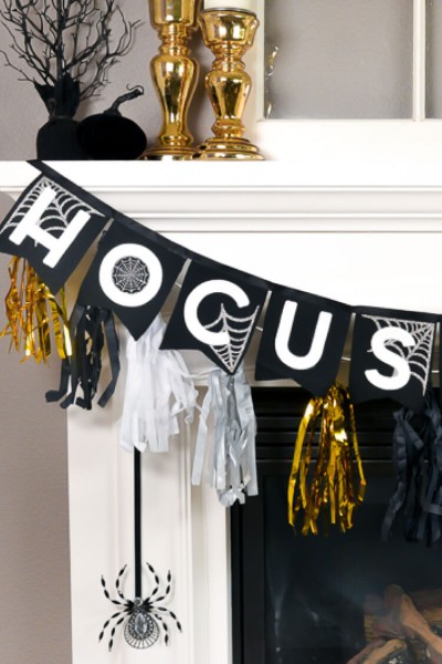 Close up of partial black, white and gold banner that is hanging from a white fireplace mantel