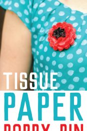 A close up of a woman in a blue polka dotted shirt with a paper poppy pinned to it with advertising of a tissue paper poppy pin from HEYLETSMAKESTUFF.COM