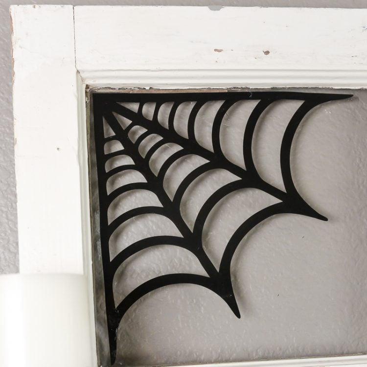 Close up of the corner of a window decorated with a black spiderweb