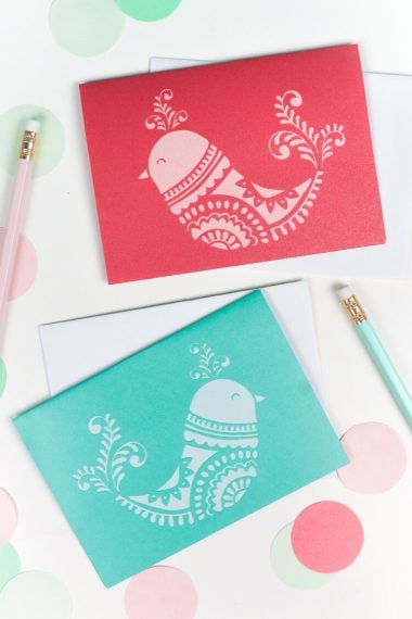 Two pencils, two envelopes and two cards with a design of a bird on them