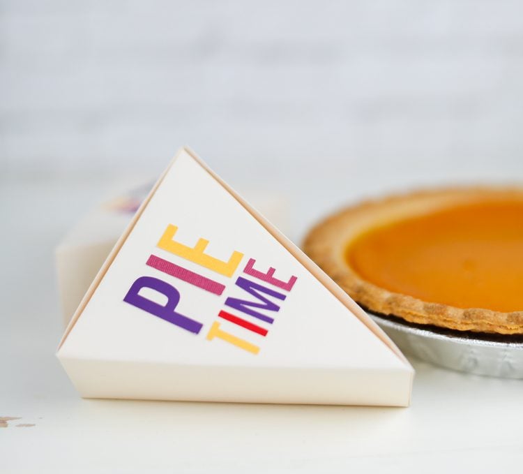 A pumpkin pie and box next to it with the saying \"Pie Time\" on it
