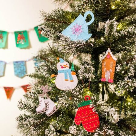 Christmas ornaments cut out of felt hanging on a Christmas tree