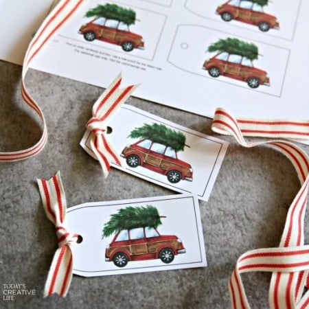 Images of Christmas gift tags that have a picture of a red car with a Christmas tree tied to the top of the car