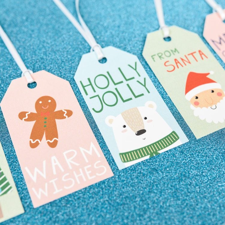 Close up of a Christmas gift tags that say, \"From Santa\", \"Holly Jolly\" and \"Warm Wishes\"