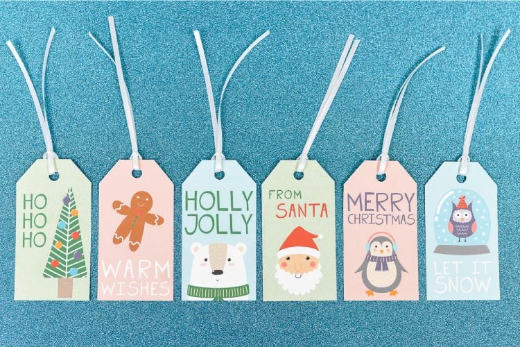 Close up of Christmas gift tags that say, \"Merry Christmas\", \"From Santa\", \"Holly Jolly\" and Warm Wishes