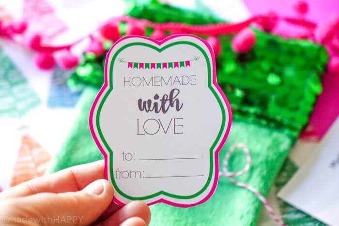 A hand holding a Christmas gift tag that says, \"Homemade with Love\"