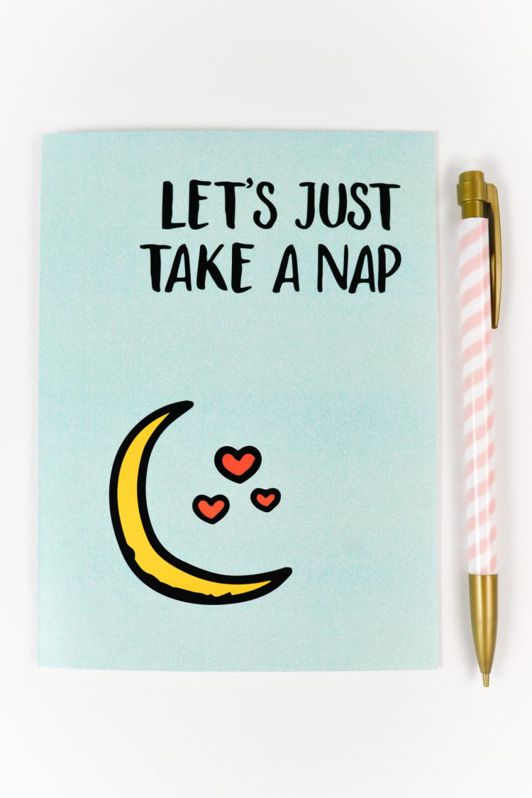 A close up of a pen and a greeting card that says, \"Let\'s Just Take a Nap\"