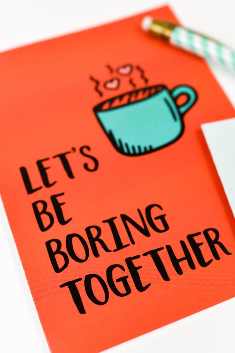 A close up of a pen and a greeting card that says, \"Let\'s Be Boring Together\"