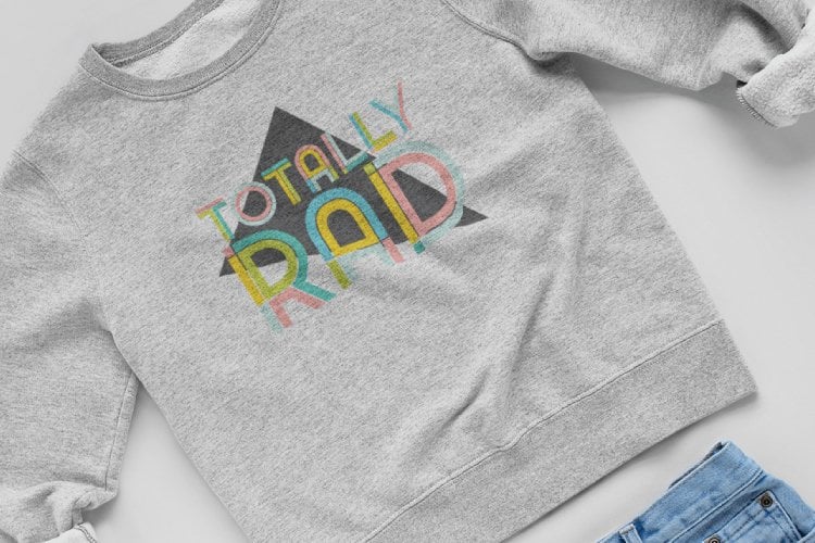 A pair of blue jeans and a gray sweatshirt that says, \"Totally Rad\"