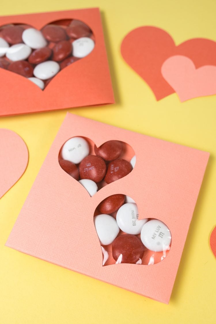 Close up of hearts cut from paper and Valentine cards filled with candy